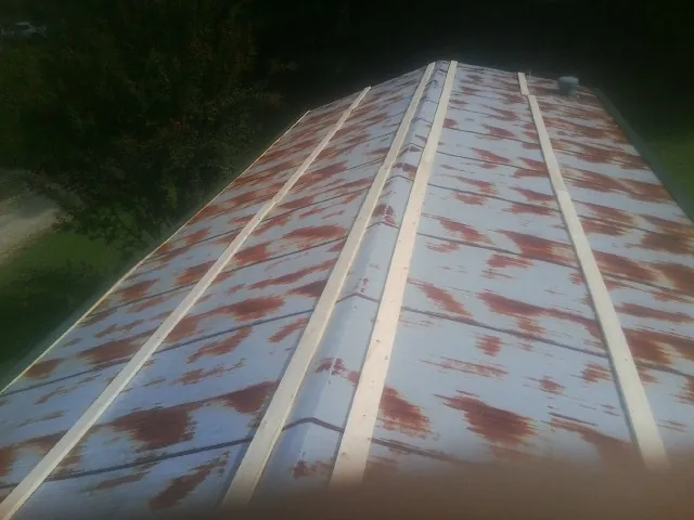 Rusted metal roof panels with new wood purlins before replacement — Storm Damage Roof Repair in Simms by Roofing Brothers